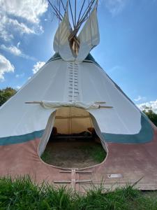 a large tent is set up in the grass at Tipidorf im Klax Natur- und Umweltcamp in Klocksin