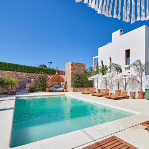 a swimming pool in front of a villa at Mar Suites Formentera by Universal Beach Hotels in Es Pujols