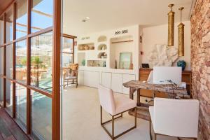 a kitchen and dining room with a table and chairs at Mar Suites Formentera by Universal Beach Hotels in Es Pujols