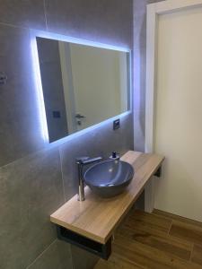a bathroom with a bowl sink and a mirror at Nibu Appartamenti - Appartamento centrale comodo a tutto in Casalecchio di Reno