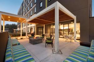 un patio con tumbonas y una hoguera en Home2 Suites By Hilton Hasbrouck Heights, en Hasbrouck Heights