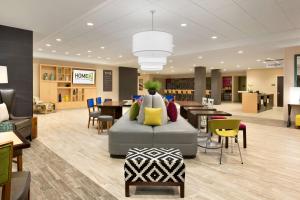 a lobby with a couch and tables and chairs at Home2 Suites By Hilton Hasbrouck Heights in Hasbrouck Heights