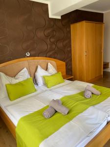 ein Bett mit grüner und weißer Bettwäsche und zwei Handtüchern in der Unterkunft Gasthof Restaurant Steirereck'n in Schwanberg