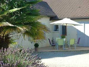un patio con mesa, sillas y sombrilla en Chambres D'hôtes Bel'vue en Chauvigny