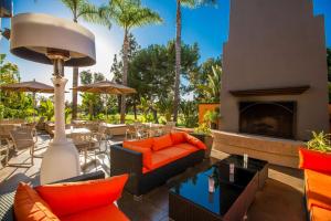 an outdoor patio with orange furniture and a fireplace at Hilton Garden Inn Montebello / Los Angeles in Montebello