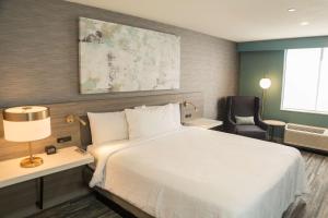 Habitación de hotel con cama blanca y silla en Hilton Garden Inn Montebello / Los Angeles en Montebello