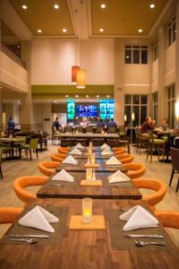 a long table with napkins and utensils in a restaurant at Hilton Garden Inn Montebello / Los Angeles in Montebello