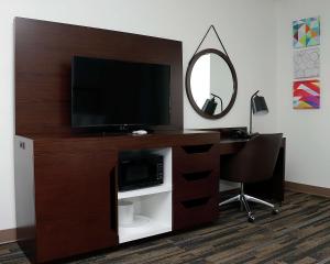 a room with a desk with a television and a mirror at Hampton Inn and Suites Stephenville in Stephenville