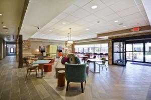 a lobby with chairs and tables in a building at Home2 Suites By Hilton Carbondale in Carbondale