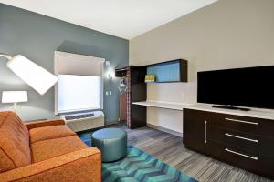 a living room with a couch and a flat screen tv at Home2 Suites By Hilton Carbondale in Carbondale