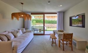 Mar Suites Formentera by Universal Beach Hotels في إس بوخولس: غرفة معيشة مع أريكة وطاولة