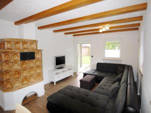 a living room with a couch and a tv at Birkenhof in Taching am See