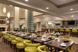 um restaurante com mesas de madeira e cadeiras amarelas em Hilton Garden Inn Statesville em Statesville