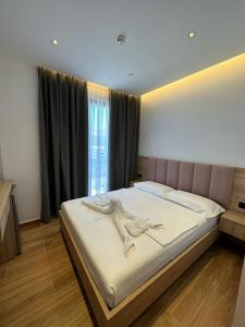 una camera con un grande letto con testiera rosa di GL Hotel Ksamil a Ksamil