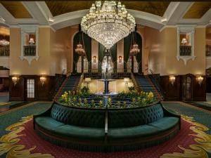 a large lobby with a large chandelier and stairs at Amway Grand Plaza Hotel, Curio Collection by Hilton in Grand Rapids