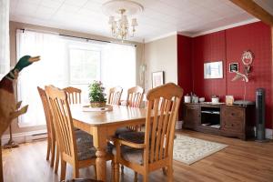 - une salle à manger avec une table et des chaises en bois dans l'établissement Bed & café Petit Papillon, à Grandes-Bergeronnes
