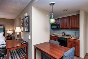 uma pequena cozinha com uma secretária e um quarto em Homewood Suites by Hilton Portland em Scarborough