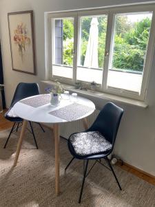 einen Tisch und Stühle in einem Zimmer mit Fenster in der Unterkunft Bergisches Cottage Solingen in Solingen