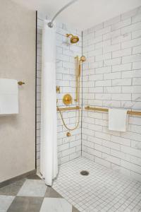 a bathroom with a shower with white tiles at Hilton Pearl River in Pearl River