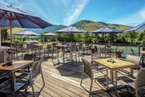 a row of tables and chairs with umbrellas on a deck at DoubleTree by Hilton Missoula Edgewater in Missoula
