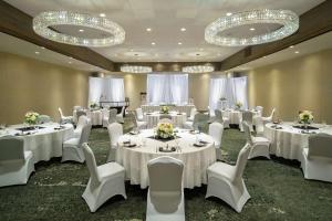 a banquet room with white tables and chairs and chandeliers at DoubleTree by Hilton Missoula Edgewater in Missoula