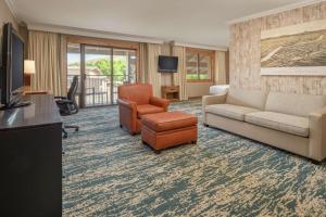 a living room with a couch and chairs and a television at DoubleTree by Hilton Missoula Edgewater in Missoula