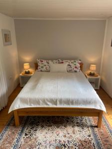 ein Schlafzimmer mit einem Bett mit zwei Lampen an zwei Tischen in der Unterkunft Bergisches Cottage Solingen in Solingen