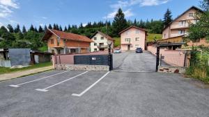 Gornje PaleにあるApartmani Klačarの一部の家の前に門のある駐車場