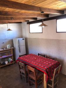 una cucina con tavolo, sedie e frigorifero di REMODELAMOS casa sobre el rio a 100 mts del mercado municipal a Tilcara