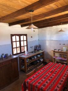 una cucina con tavolo e un letto in una camera di REMODELAMOS casa sobre el rio a 100 mts del mercado municipal a Tilcara