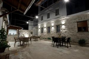 a patio with tables and chairs at night at GUEST HOUSE ÇANI in Gjirokastër