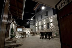 an outdoor patio with tables and chairs at night at GUEST HOUSE ÇANI in Gjirokastër