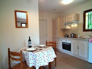 a kitchen with a table with a bottle of wine at Detached house with dishwasher in south Dordogne in Gavaudun