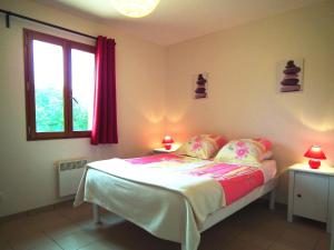 a bedroom with a bed with two lamps and a window at Detached house with dishwasher in south Dordogne in Gavaudun