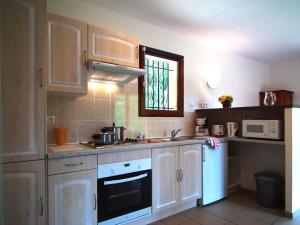 a kitchen with white cabinets and a window at Detached house with dishwasher in south Dordogne in Gavaudun