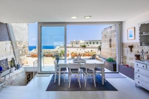 a kitchen with a table and chairs and a large window at Valletta Bastions Seafront House in Valletta