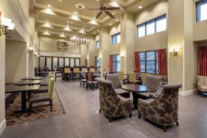 un comedor con mesas, sillas y ventanas en Hampton Inn & Suites Baton Rouge - I-10 East en Baton Rouge