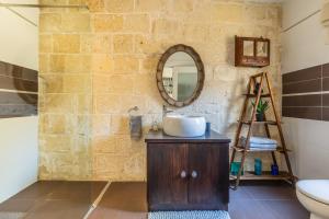 uma casa de banho com um lavatório e um espelho na parede em Valletta Bastions Seafront House em Valeta