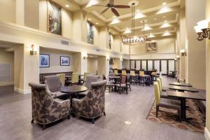 um restaurante com mesas e cadeiras e uma sala de jantar em Hampton Inn & Suites Baton Rouge - I-10 East em Baton Rouge