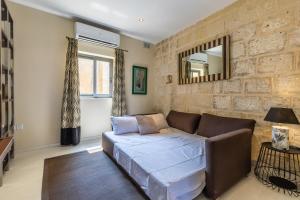 a living room with a couch and a mirror at Valletta Bastions Seafront House in Valletta