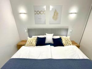 sypialnia z dużym łóżkiem z niebieskimi i żółtymi poduszkami w obiekcie Luxury Apartment Turquesa Del Mar w Alicante
