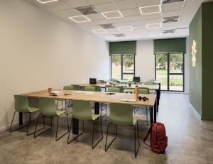 a classroom with tables and chairs and a red backpack at Micampus Burjassot Parque Residencia Universitaria in Burjasot