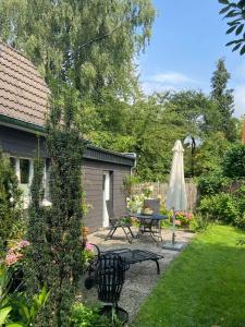 a patio with a table and an umbrella at Bergisches Cottage Solingen in Solingen