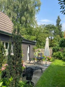 eine Terrasse mit Tisch und Sonnenschirm in der Unterkunft Bergisches Cottage Solingen - Tiny House mit Garten in Solingen
