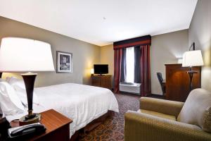 a hotel room with a bed and a chair at Hampton Inn & Suites Brenham in Brenham