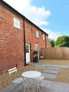 a patio with chairs and a table and a brick building at The Dairy in Brereton cum Smethwick