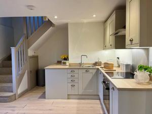 a kitchen with a sink and a staircase at The Dairy in Brereton cum Smethwick