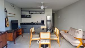 uma sala de estar com mesa e cadeiras e uma cozinha em Qavi - Flat em Pirangi Living #PirangiChalé13 em Parnamirim