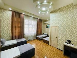 een slaapkamer met 2 bedden en een bank. bij Alisher Hotel by SHOSH in Tasjkent