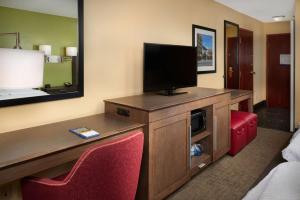 a hotel room with a television and red chairs at Hampton Inn Shelbyville in Shelbyville